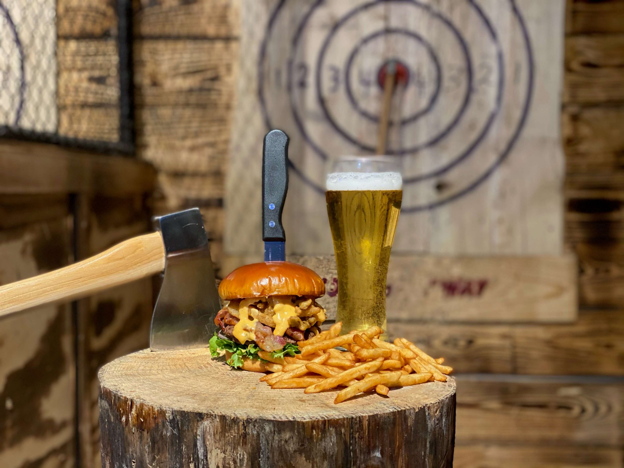 Cheeseburger and fries in an axe throwing lane at JD's veteran-owned business